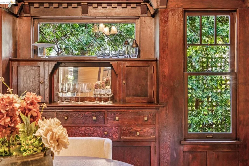 Incredible built-in wood cabinetry featuring a mirrored wet bar, integrated storage, and an upper display shelf