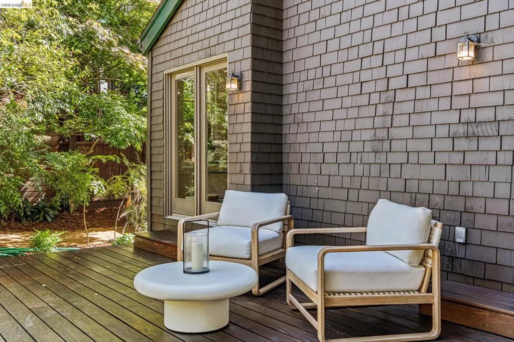 Wood-deck patio featuring shake siding and outdoor wall sconces