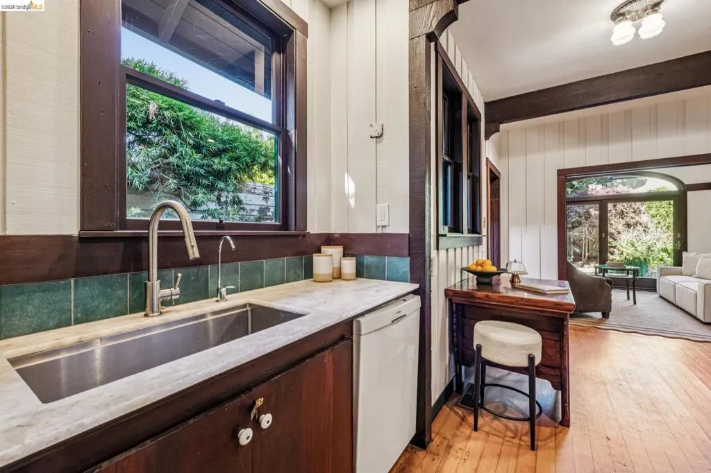 Kitchen area featuring a stainless steel undermounted sink with a gooseneck faucet, white stone countertop, and beautiful green hand crafted tile backsplash