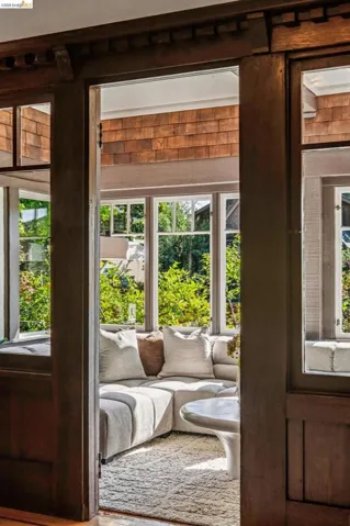 Here is where it gets really good! The sunroom featuring extensive window-lines, wood shingle wall accent, and wood-finish trim