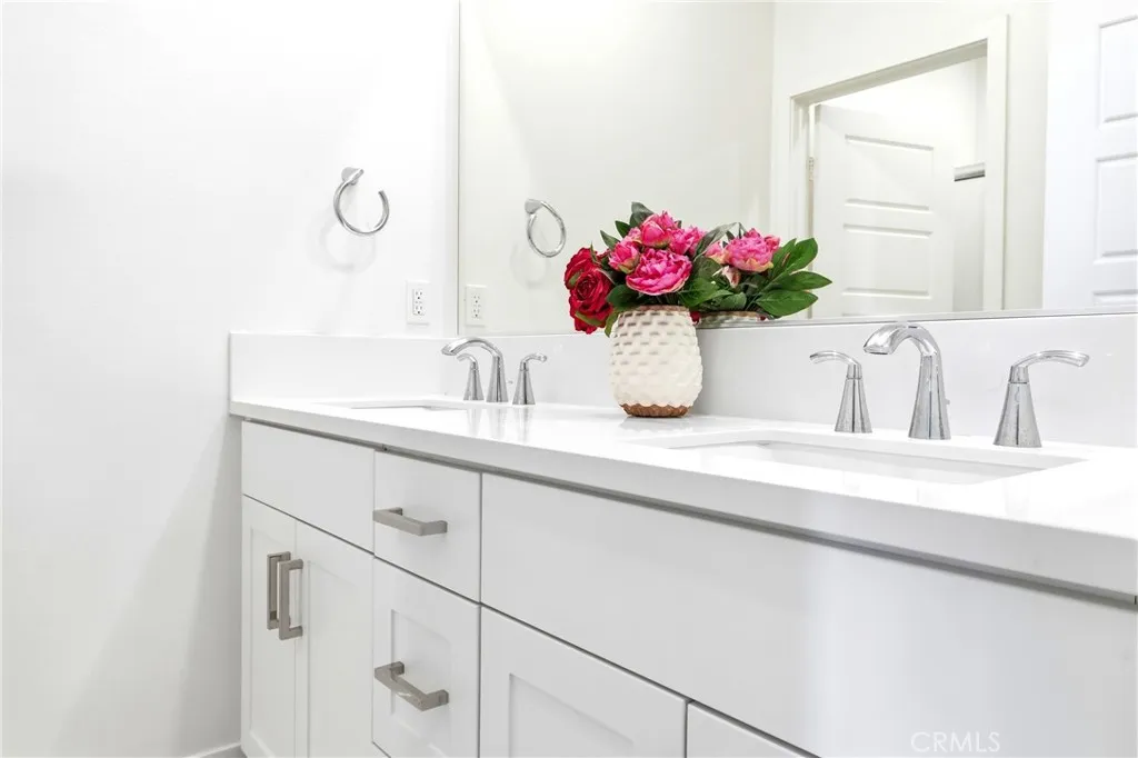 hall bathroom with dual sinks.