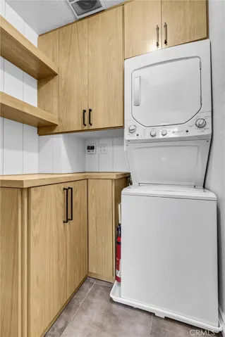 Laundry room with stackable washer and​​‌​​​​‌​​‌‌​​‌​​​‌‌​​​‌​​‌‌​​‌‌​​‌‌​​​​ dryer.