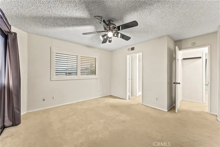 Plantation shutters and ceiling fan in primary bed 1