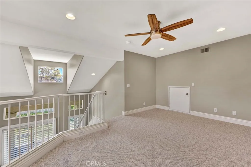 This loft space is ideal for a versatile home office or an inviting area for entertaining.