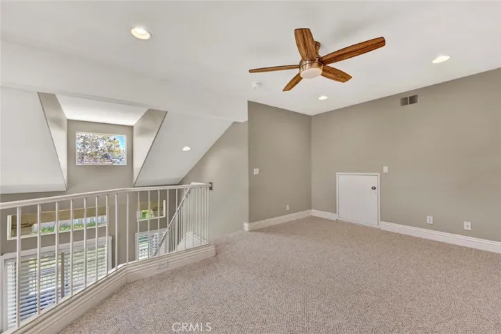 This loft space is ideal for a versatile home office or an inviting area for entertaining.