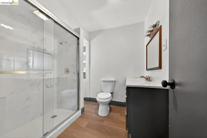 Walk-in shower with clear glass enclosure and large format tile surround