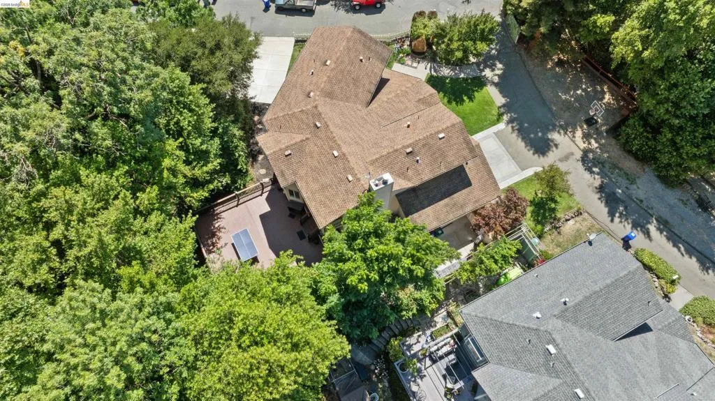 Multi-gabled roofline residence with a spacious rear deck, surrounded by mature trees