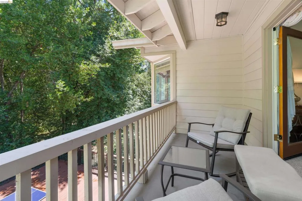 Private balcony with beadboard ceiling and outdoor wall sconce