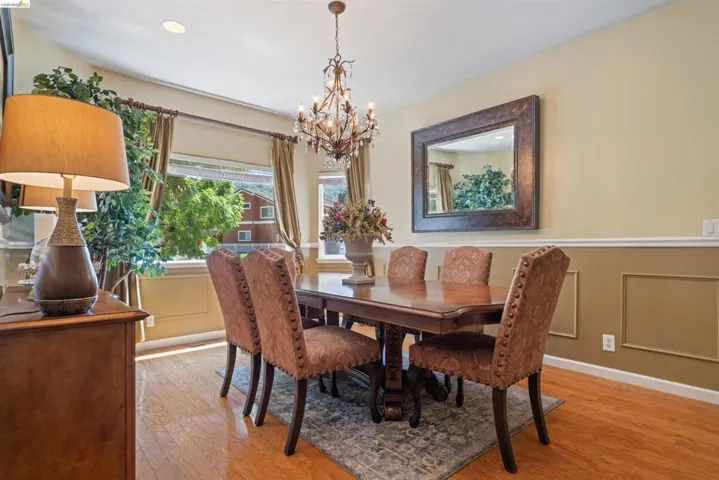 Formal dining space featuring wood-finish flooring, a decorative chandelier, recessed lighting, and chair rail molding