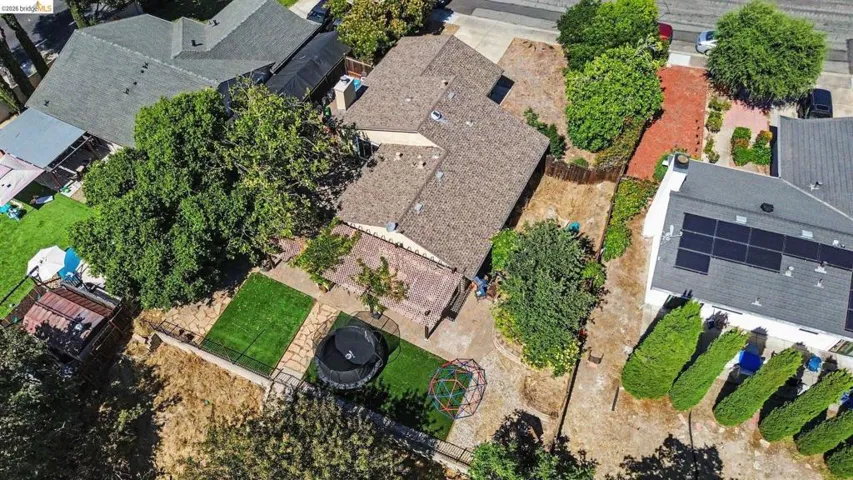 Single-story residence featuring a shingle roof and a spacious backyard with a deck