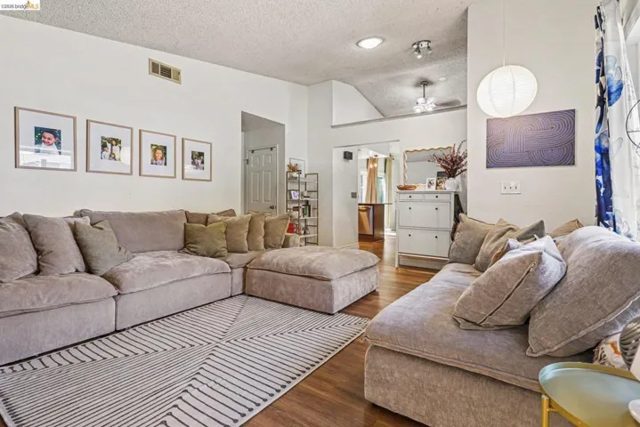 Living area featuring wood-finish flooring, a vaulted ceiling, and recessed lighting
