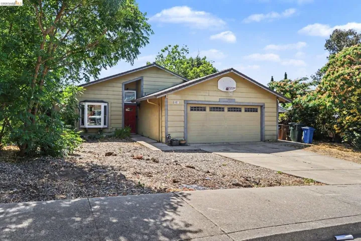 Single-story residence featuring a two-car garage with a basketball hoop