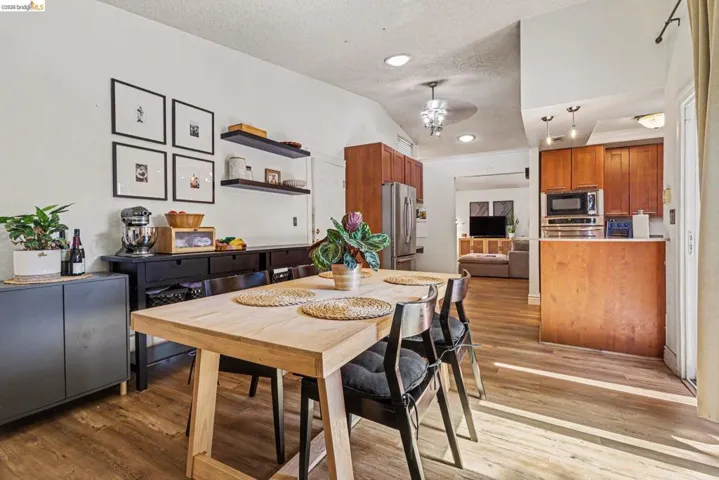 Open-concept living space featuring wood-finish flooring, recessed lighting, and vaulted ceilings