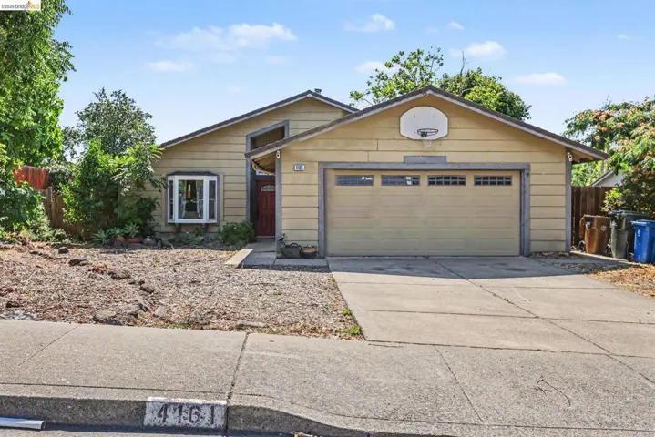 Single-story residence featuring a bay window, concrete driveway, attached garage, and a covered entry