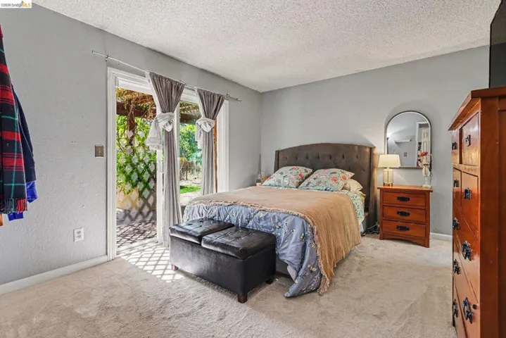 Room featuring wall-to-wall carpeting, light gray wall paint, and a sliding glass door to an outdoor area