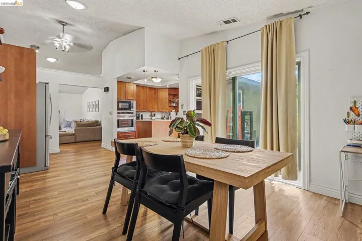 Open-concept dining area featuring wood-finish flooring, recessed lighting, and a sliding glass door