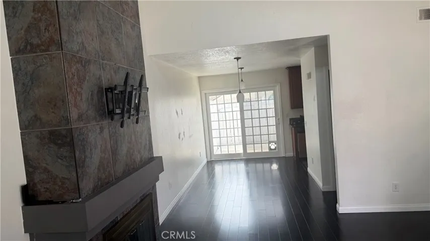 Living-room with slate stone fireplace, looking towards dining and kitchen