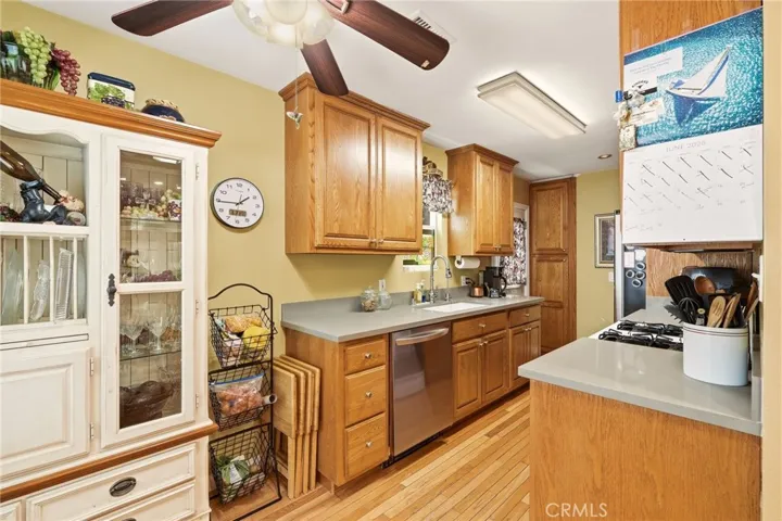 Another view of the updated kitchen featuring a newer dishwasher, abundant cabinetry, and generous counter space.