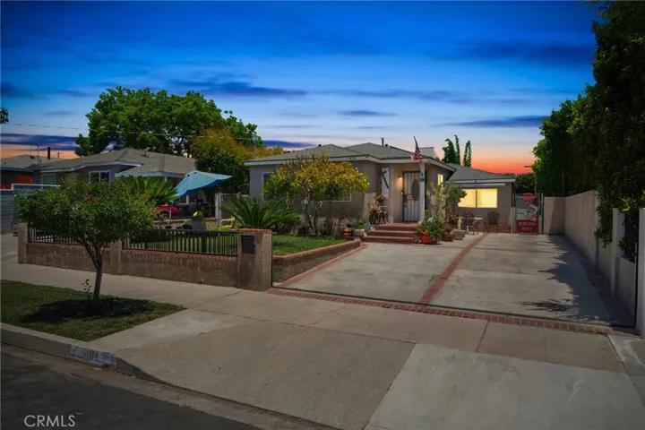 Stunning twilight setting enhances this inviting home with manicured landscaping and gated driveway, creating exceptional evening curb appeal.