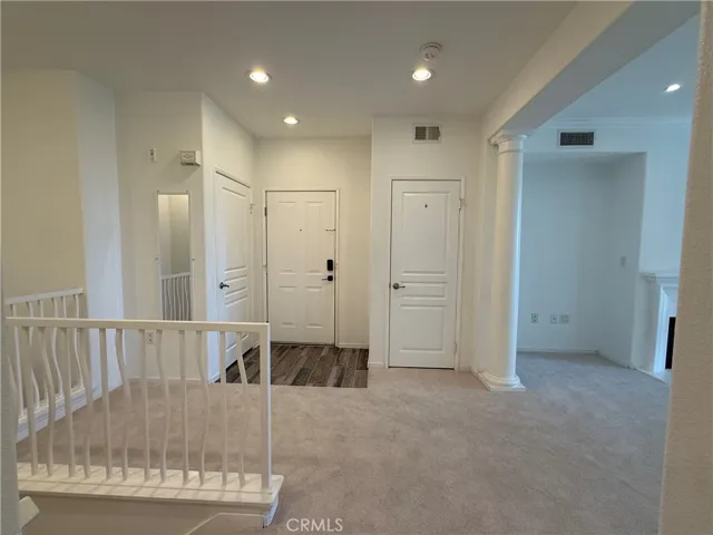 Kitchen looking back at the front door, hall closet and upstairs bathroom