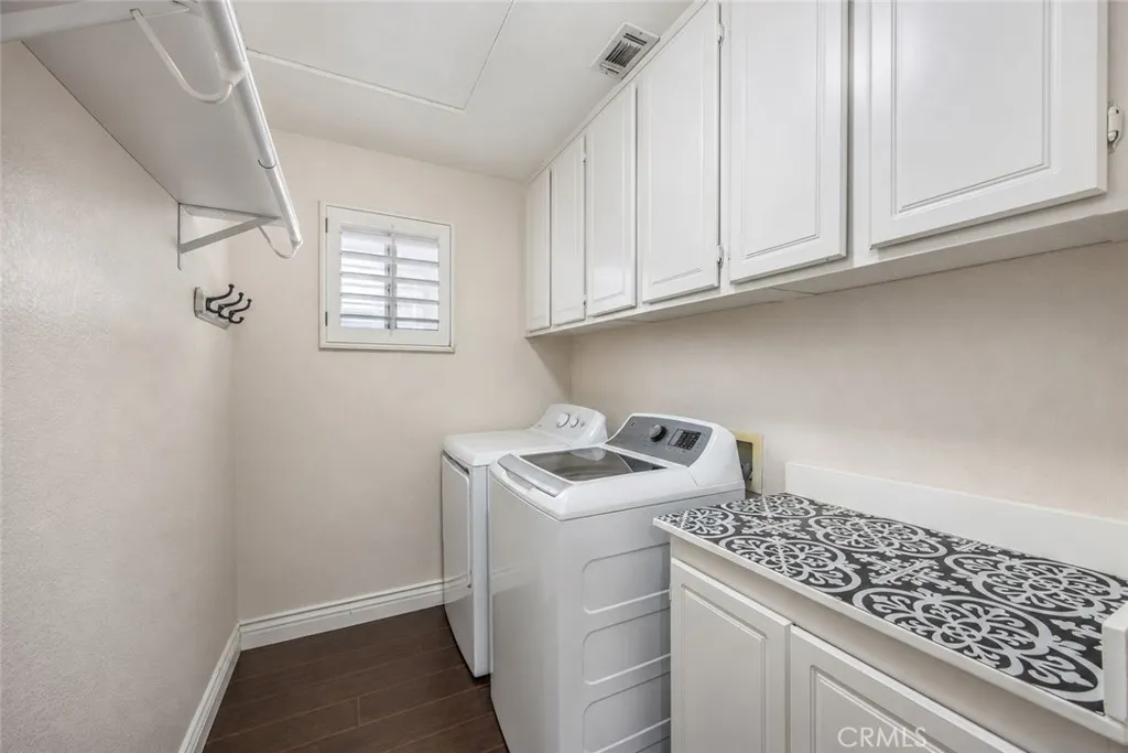 The upstairs laundry room features extensive cabinetry for added organization and storage