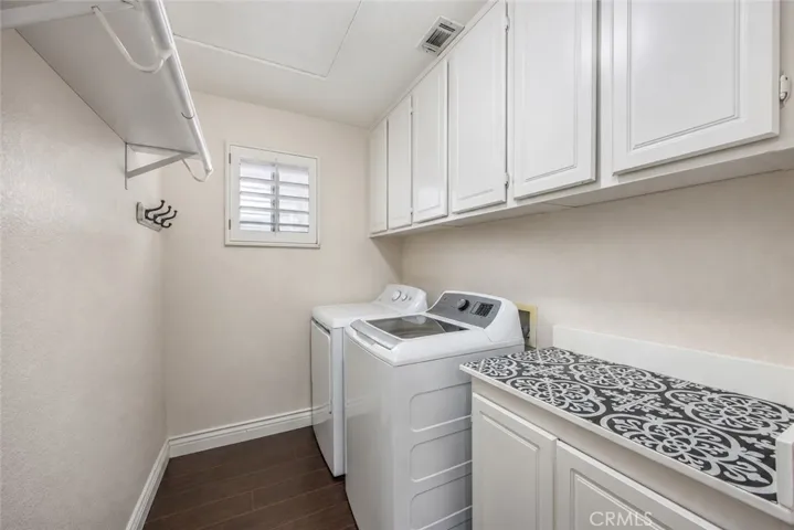The upstairs laundry room features extensive cabinetry for added organization and storage