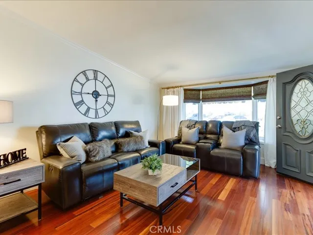 Large, cozy living room with engineered hardwood floors
And bay window