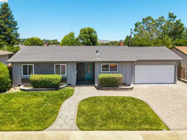 Ranch-style exterior with gray vertical siding, a teal front door, and a two-car garage