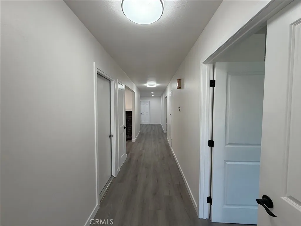 Entry hallway with new flooring, fresh paint, new doors, modern hardware, and updated lighting.