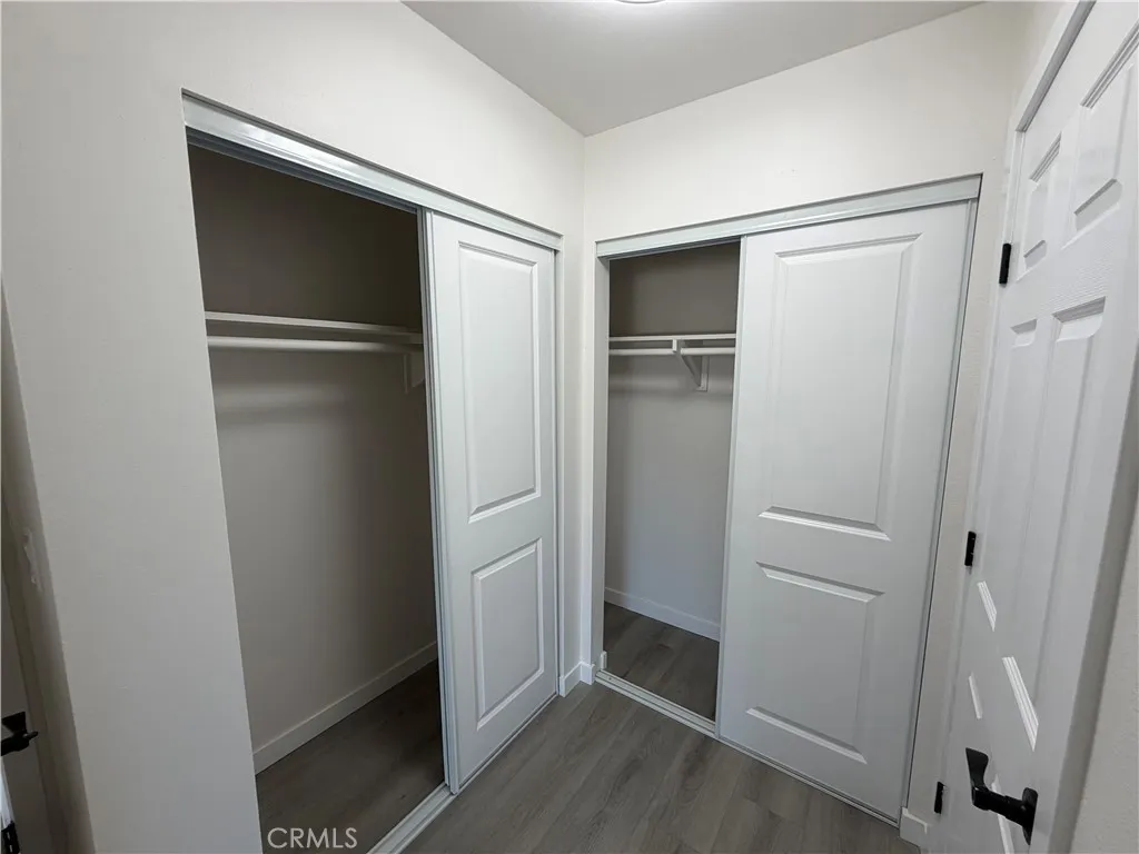 Primary closet space with new closet doors, new flooring, fresh paint, and modern hardware.