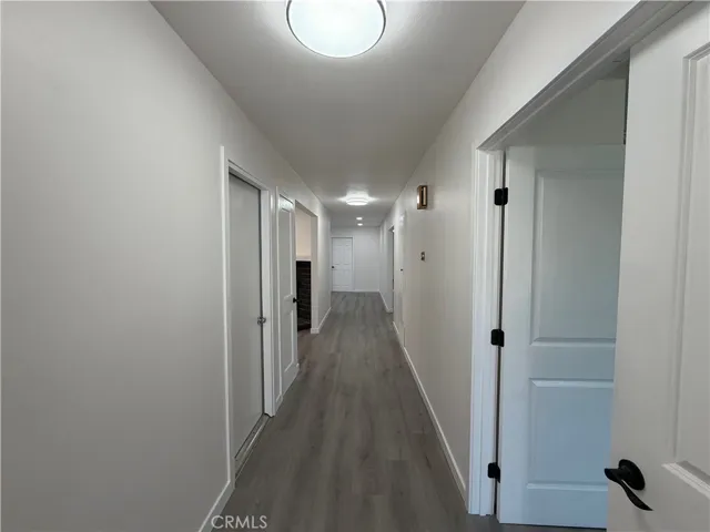 Entry hallway with new flooring, fresh paint, new doors, modern hardware, and updated lighting.