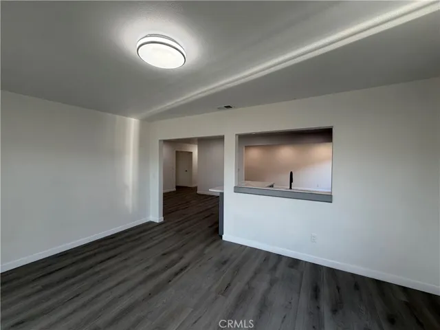 Dining area with new flooring, updated lighting, and open pass-through access to the kitchen with backyard access.