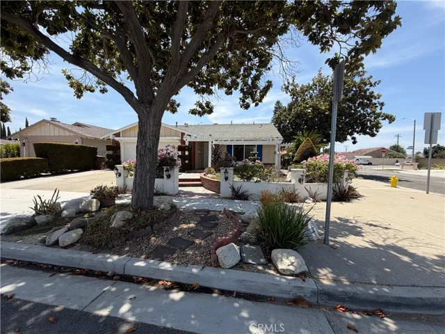 Single story home with mature shade tree, low-maintenance front landscaping.