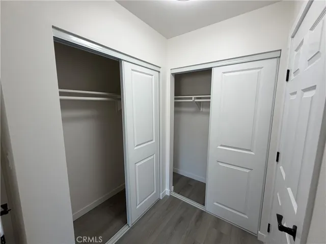 Primary closet space with new closet doors, new flooring, fresh paint, and modern hardware.