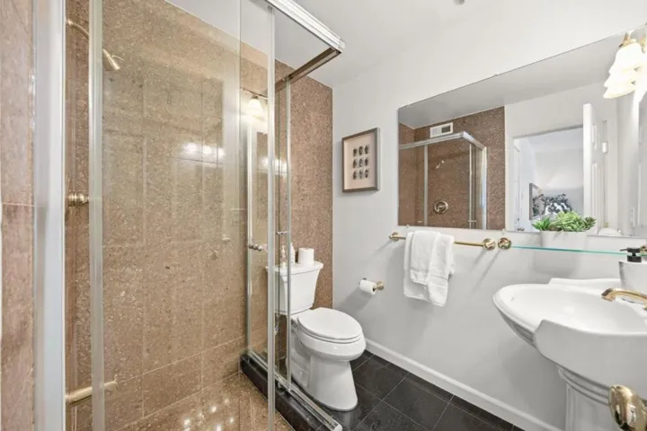 Ground floor full bath with shower stall, adjacent to ground floor bedroom.