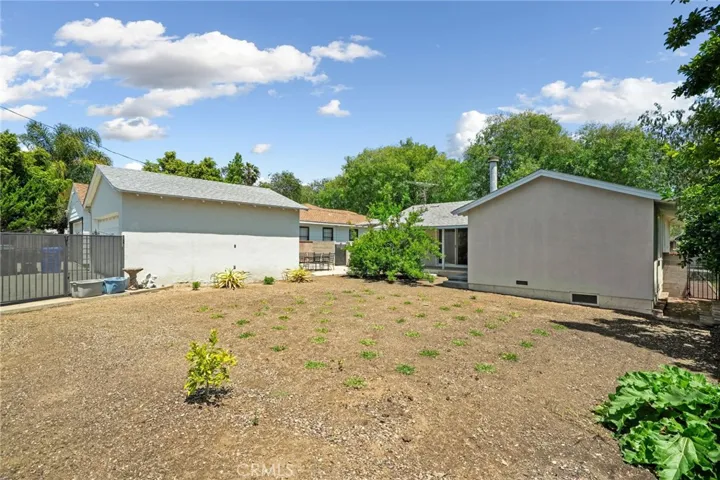 Large Open back yard space with grass that has been planted.