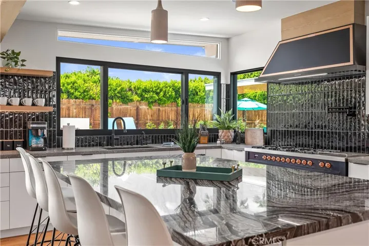 "Expansive stone island anchors this beautifully reimagined kitchen, blending modern luxury with classic Palm Springs style."
