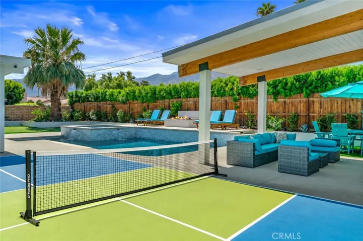 Private backyard featuring a pool,spa,covered outdoor living space with TV surround sound,fireplace ,fire pit,putting green,ands Pickleball with Mountain views.