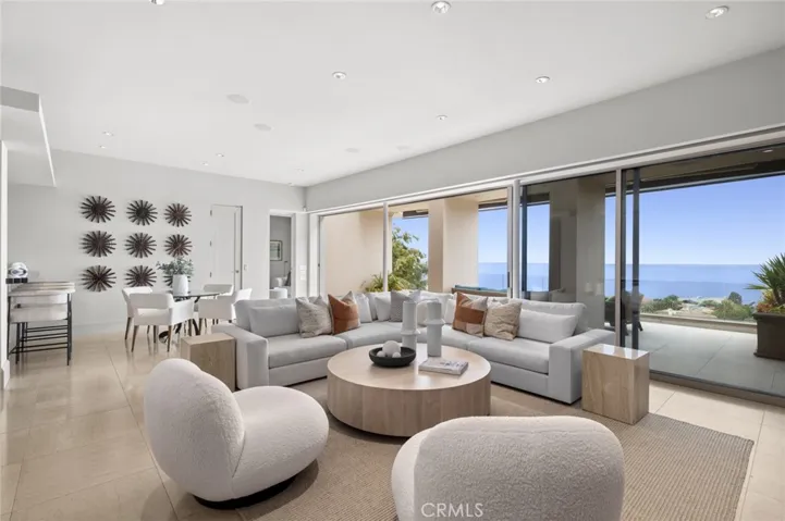 Generously sized decking off a secondary grand living room with a bar area extends the living spaces and includes an outdoor kitchen with vistas capturing colorful sunsets and ever-changing skies.