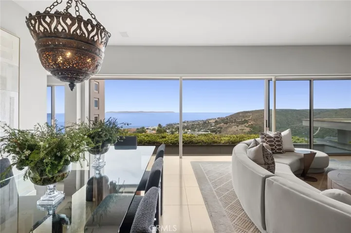 The living room serves as a striking gathering space, highlighted by a gas fireplace with a black granite surround and Macassar ebony mantel, while Pacific Ocean, canyon, and city-light views lend ambiance to both entertaining and everyday living.