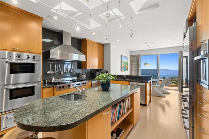 The kitchen, designed for both daily living and entertaining, features a large island, 5 Star gas range, Thermador double ovens and warming drawer, two Bosch dishwashers, and a Sub-Zero Pro refrigerator/freezer.