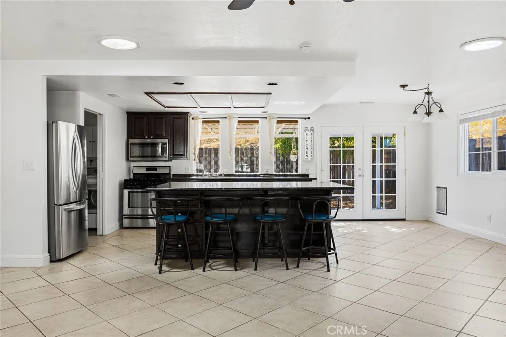 Kitchen – Spacious kitchen featuring a large center island with seating, granite countertops, stainless steel appliances, and a walk-in pantry.