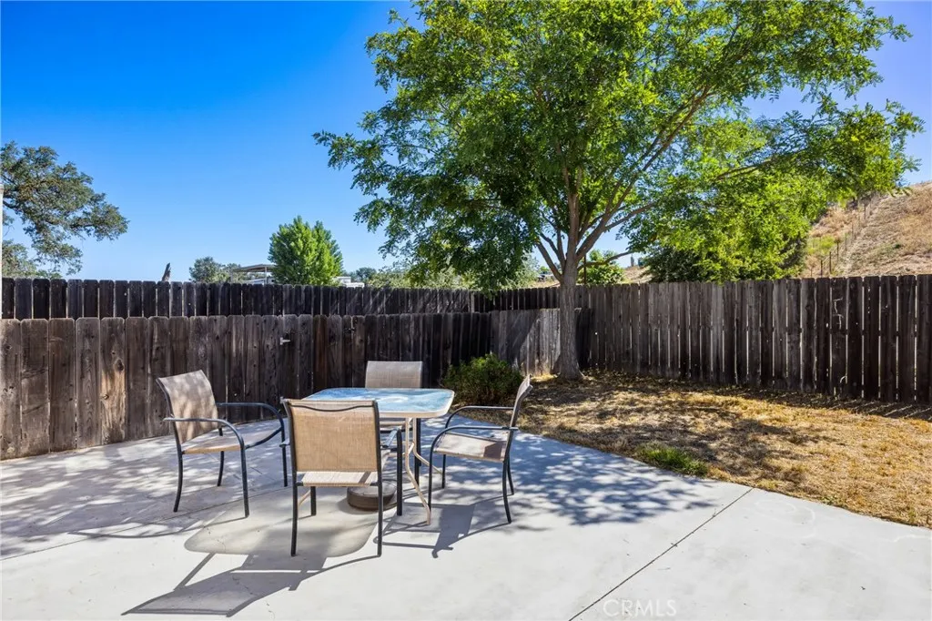 Guest House Backyard – Private fenced backyard with a spacious patio, mature shade tree, and room for outdoor dining or relaxation.