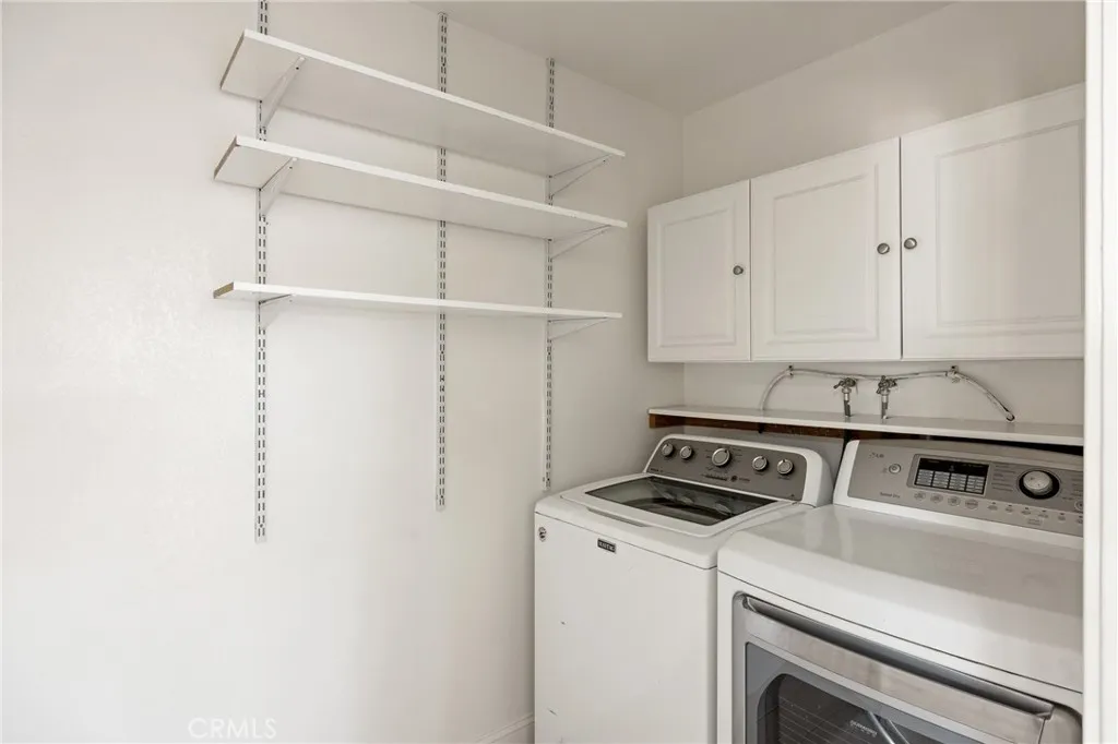 Laundry & Pantry Storage Area – Dedicated laundry room with built-in cabinetry and extensive shelving, providing convenient storage and organization.