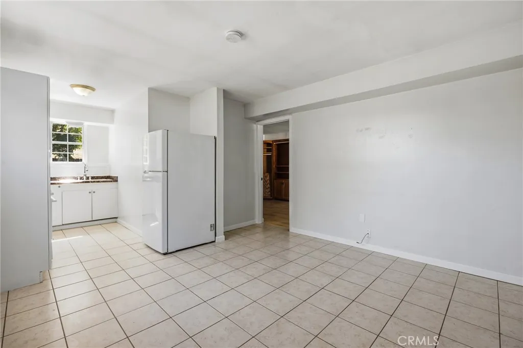 Guest House Living Area – Bright and open living space with tile flooring, natural light, and an easy flow into the kitchenette and adjoining rooms.