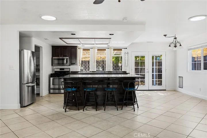 Kitchen – Spacious kitchen featuring a large center island with seating, granite countertops, stainless steel appliances, and a walk-in pantry.