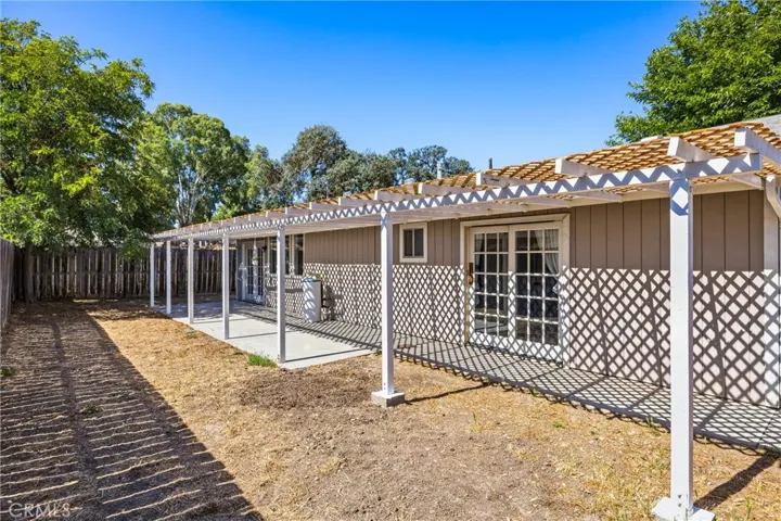 Backyard – The main residence opens to a covered patio with pergola-style shade structures and multiple French doors, creating seamless indoor-outdoor living and entertaining space.