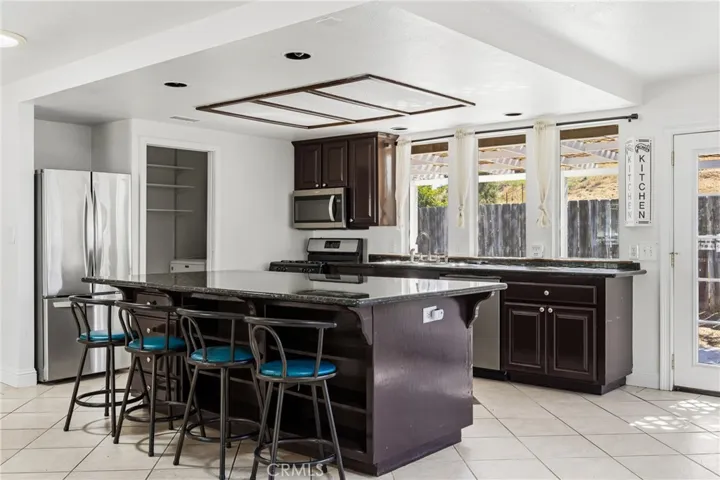 The Kitchen is filled with natural light from numerous windows and enjoys pleasant views of the backyard patio, adjacent is the laundry with pantry storage
