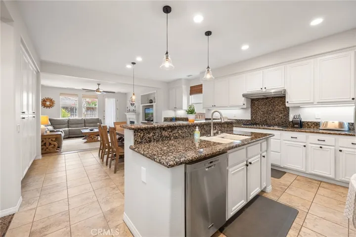Remodeled Kitchen with Granite Countertops & Backsplash, White Cabinets with custom Hardware, Stainless Steal Appliances and Pendant Lighting