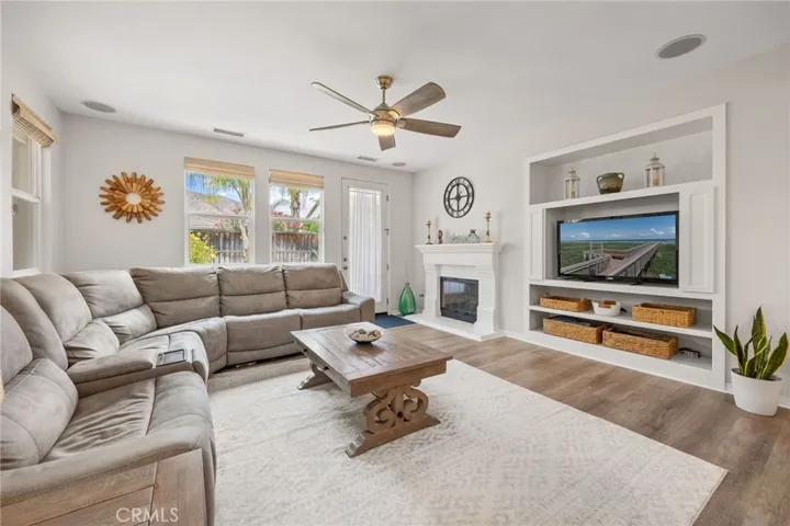Family Room with built-in Speakers, Entertainment Center, custom White Mantel & Fireplace and Backyard access